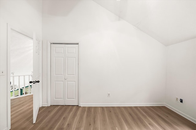 additional living space featuring light wood-type flooring, baseboards, and lofted ceiling