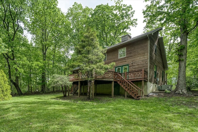 rear view of property featuring stairway, a deck, a lawn, a chimney, and cooling unit
