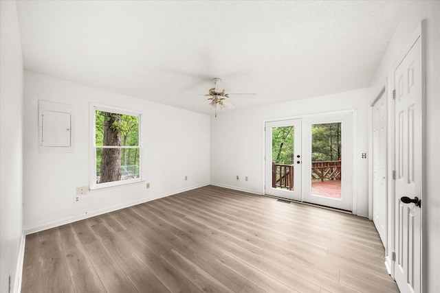spare room featuring plenty of natural light, light wood-style flooring, french doors, and ceiling fan