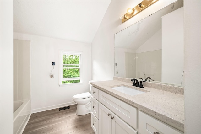 full bath with vaulted ceiling, toilet, wood finished floors, a shower, and vanity