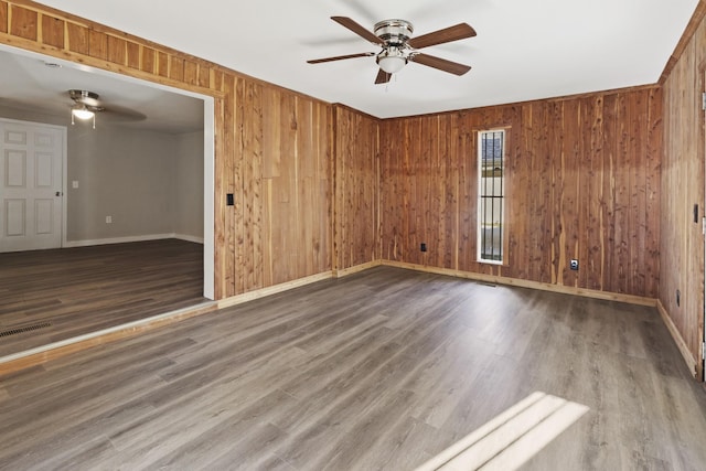 1405 W Lincoln St, Tullahoma, TN 37388 - spare room featuring a ceiling fan, baseboards, wooden walls, and wood finished floors