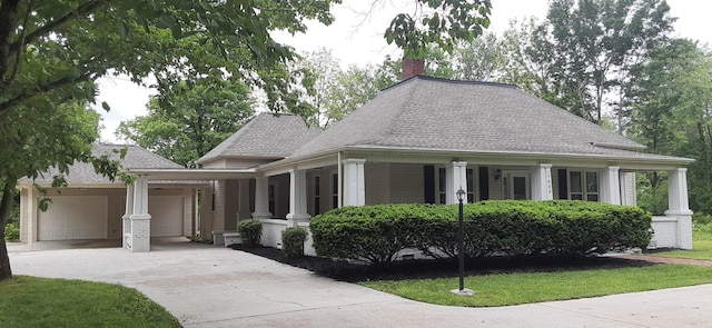 1405 W Lincoln St, Tullahoma, TN 37388 - view of front facade with concrete driveway, a garage, a chimney, covered porch, and a shingled roof