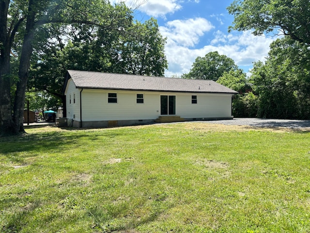 rear view of house featuring crawl space, a lawn, and entry steps