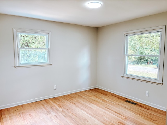 unfurnished room featuring baseboards and light wood-type flooring