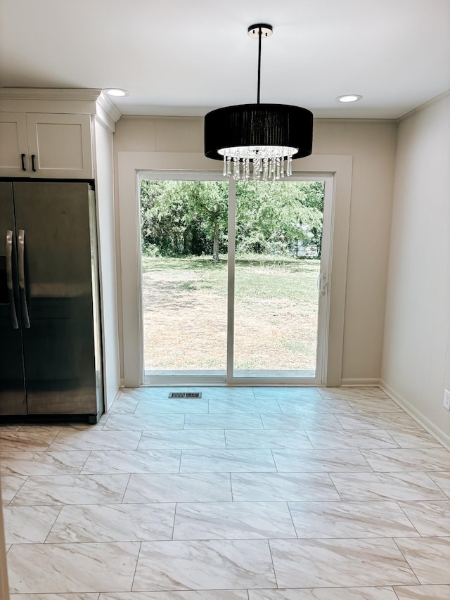 unfurnished dining area with a chandelier, light marble finish flooring, and baseboards