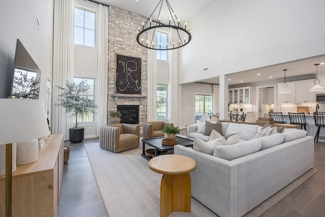 9016 Nestling Ridge Ct, College Grove, TN 37046 - living area with wood finished floors, a towering ceiling, a chandelier, and a stone fireplace