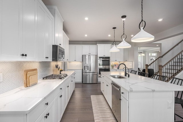 9016 Nestling Ridge Ct, College Grove, TN 37046 - kitchen with appliances with stainless steel finishes, a sink, a kitchen bar, backsplash, and recessed lighting