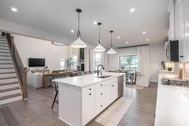 9016 Nestling Ridge Ct, College Grove, TN 37046 - kitchen with a sink, appliances with stainless steel finishes, a kitchen island with sink, dark wood-style floors, and white cabinetry