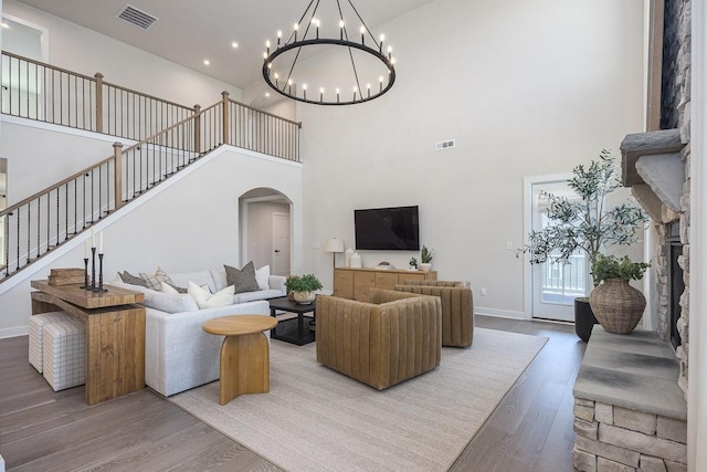 9016 Nestling Ridge Ct, College Grove, TN 37046 - living area with arched walkways, a high ceiling, stairway, wood finished floors, and a chandelier