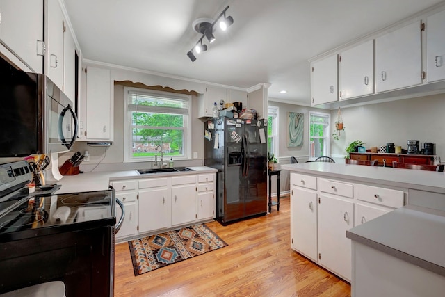 110 Marita Ave, Goodlettsville, TN 37072 - kitchen with range with electric cooktop, black fridge, a sink, light wood finished floors, and healthy amount of natural light