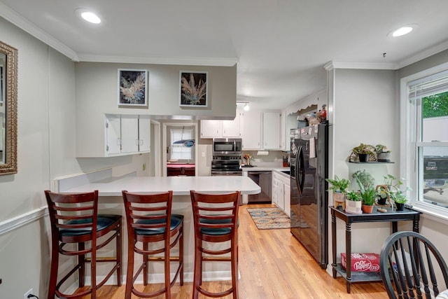 110 Marita Ave, Goodlettsville, TN 37072 - kitchen featuring stainless steel appliances, a peninsula, light wood-style floors, light countertops, and crown molding