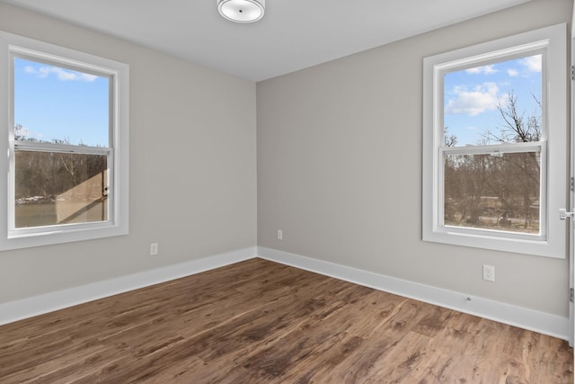 spare room featuring wood finished floors and baseboards