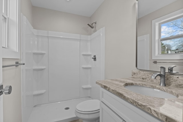 full bath featuring a shower, vanity, and toilet
