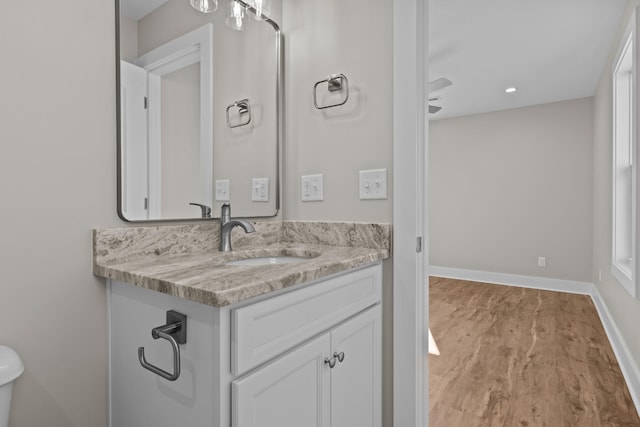 bathroom featuring vanity, wood finished floors, and baseboards