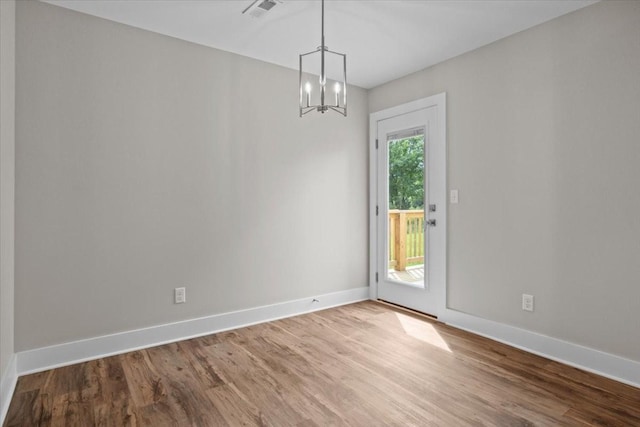 1024 Evans Rd, Burns, TN 37029 - empty room with wood finished floors, baseboards, and a chandelier
