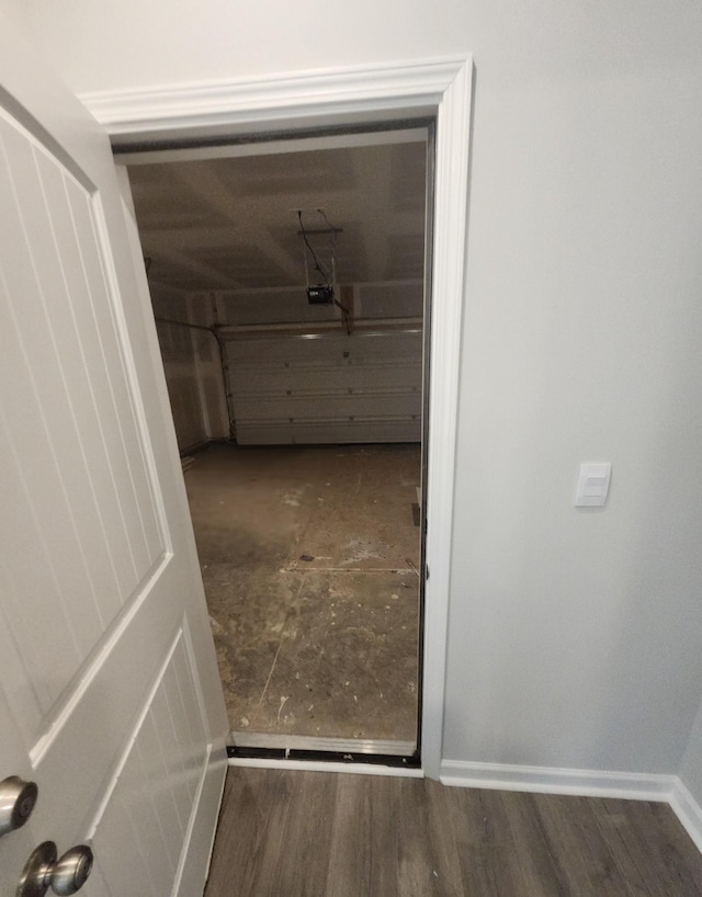 garage featuring a garage door opener and baseboards