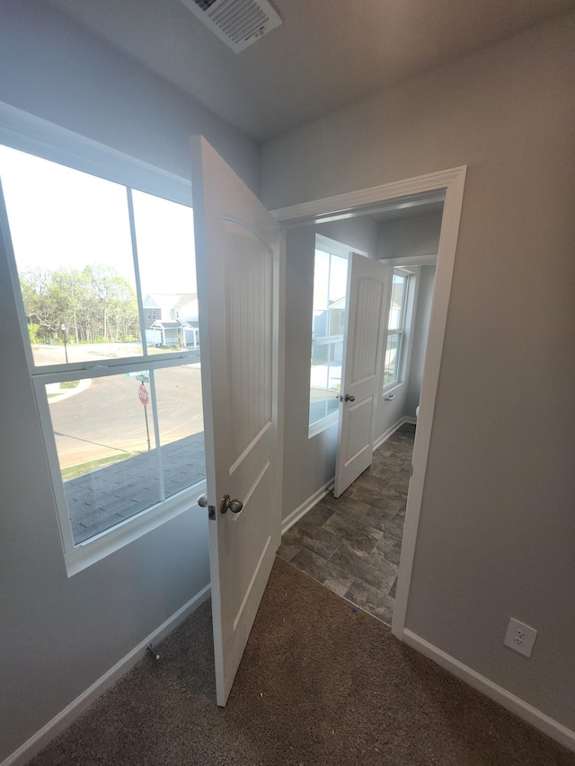 hall with baseboards and carpet