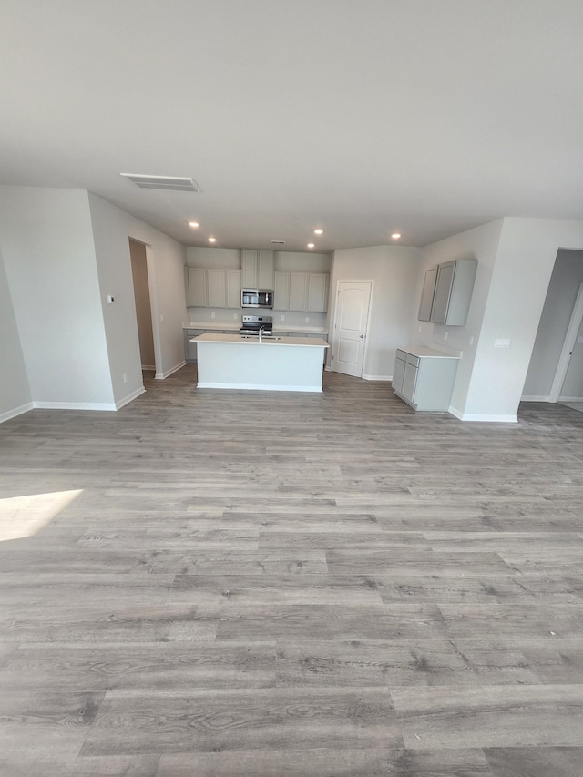 unfurnished living room with baseboards, light wood-type flooring, and recessed lighting