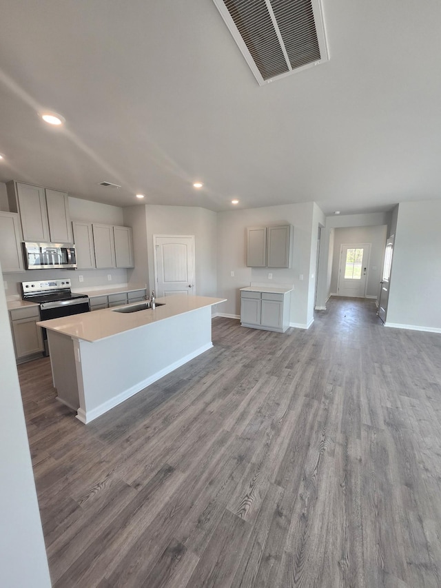 kitchen with appliances with stainless steel finishes, gray cabinets, recessed lighting, and wood finished floors