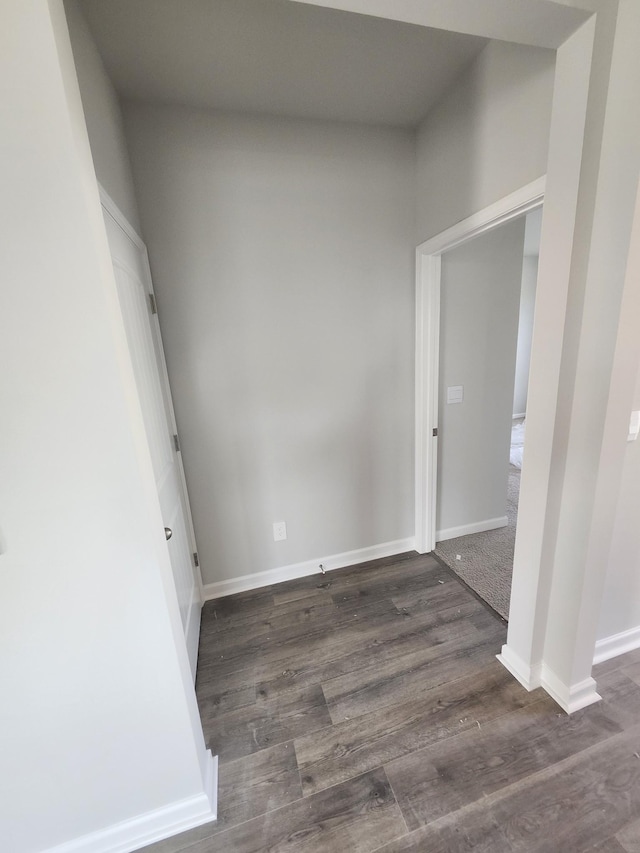 empty room with dark wood finished floors and baseboards