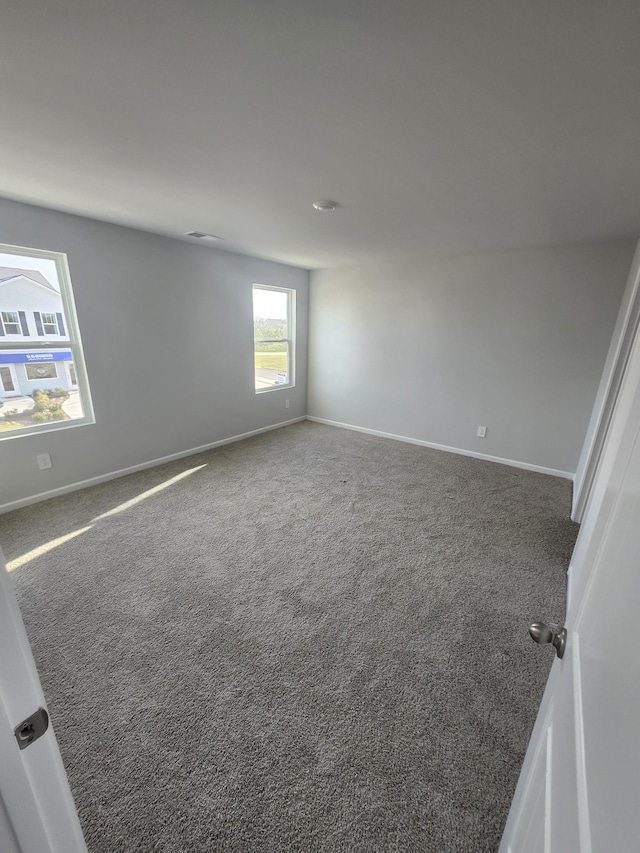 carpeted spare room with baseboards