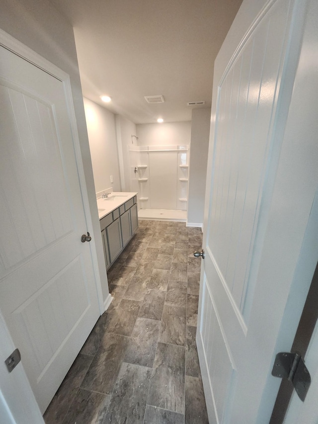 full bathroom with a shower, vanity, recessed lighting, and stone finish floors