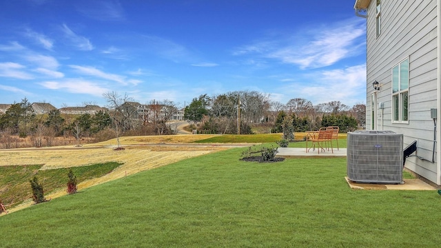 view of grassy yard featuring central AC unit and a patio