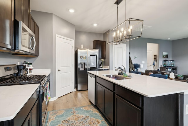 7401 Brady Ln, Antioch, TN 37013 - kitchen with stainless steel appliances, a sink, light wood-style floors, light countertops, and dark brown cabinetry