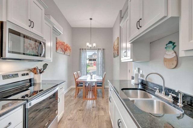 517 Main St, Burns, TN 37029 - kitchen featuring stainless steel appliances, a sink, a chandelier, light wood-style floors, and dark stone countertops