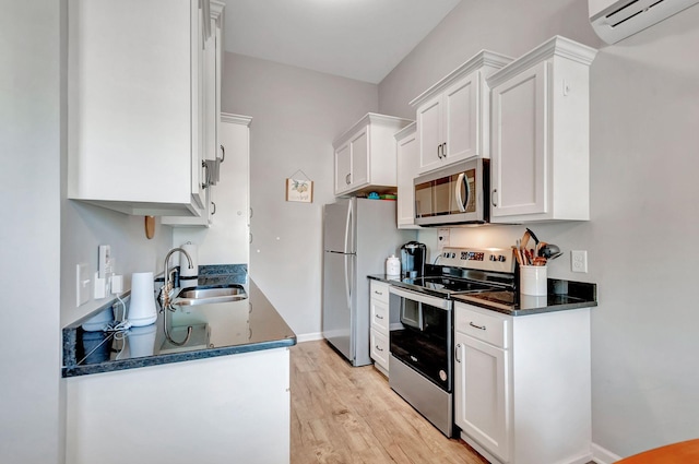517 Main St, Burns, TN 37029 - kitchen with appliances with stainless steel finishes, a sink, dark countertops, light wood-type flooring, and white cabinets