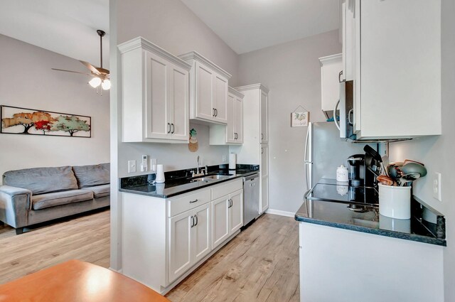 517 Main St, Burns, TN 37029 - kitchen with a sink, ceiling fan, stainless steel appliances, light wood-style flooring, and white cabinetry