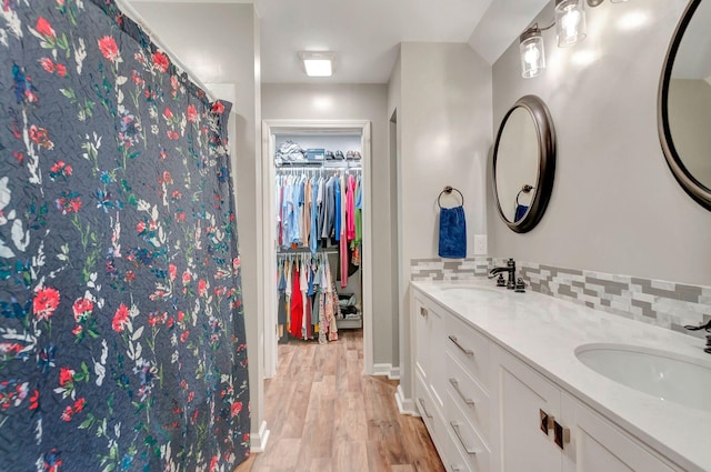 517 Main St, Burns, TN 37029 - bathroom featuring wood finished floors, double vanity, decorative backsplash, and a walk in closet
