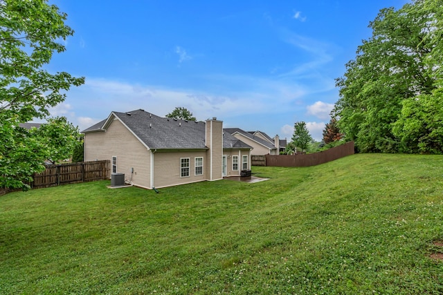 back of property featuring a chimney and central AC