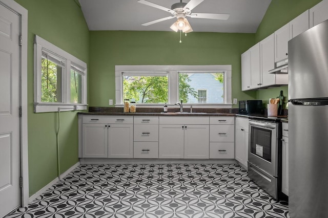 2001 E 16th St, Chattanooga, TN 37404 - kitchen featuring appliances with stainless steel finishes, white cabinetry, under cabinet range hood, healthy amount of natural light, and vaulted ceiling