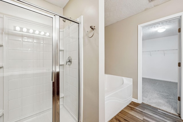 107 Owl Dr, Lebanon, TN 37087 - full bath with a shower stall, a bath, wood finished floors, a walk in closet, and a textured ceiling