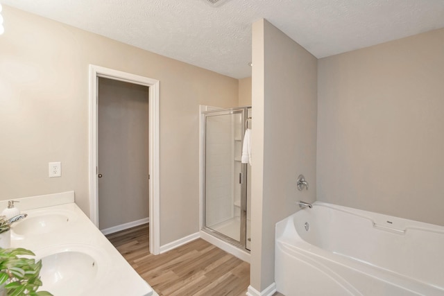107 Owl Dr, Lebanon, TN 37087 - bathroom featuring wood finished floors, a shower stall, a bath, a textured ceiling, and baseboards