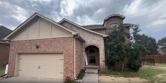 view of front facade with brick siding, fence, a garage, and concrete driveway