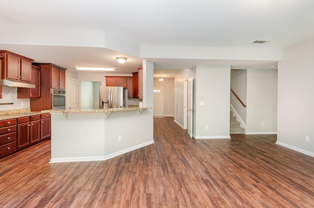 8007 Timber Cove Dr, Mount Juliet, TN 37122 - kitchen with appliances with stainless steel finishes, under cabinet range hood, baseboards, a breakfast bar, and dark wood-style flooring