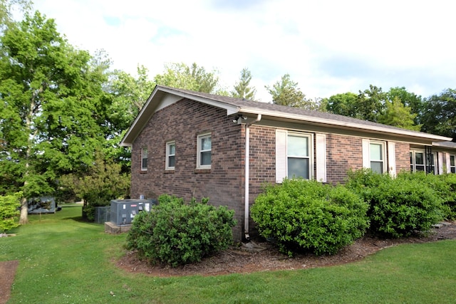 1210 Stewart Dr, Pulaski, TN 38478 - view of property exterior featuring central AC, brick siding, and a lawn