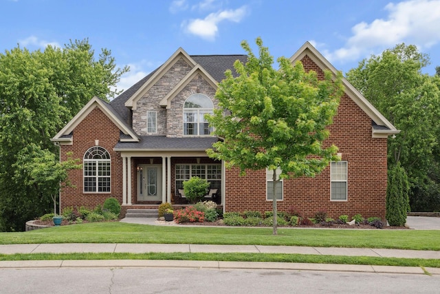 traditional-style house featuring a front lawn and brick siding