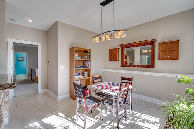 dining area with light tile patterned floors, baseboards, and a chandelier