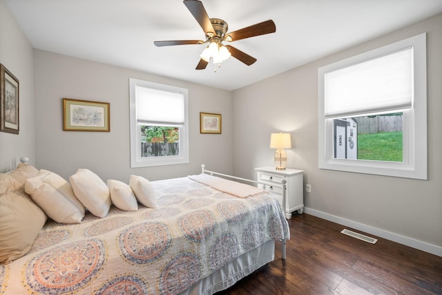 bedroom with baseboards, dark wood-type flooring, and a ceiling fan