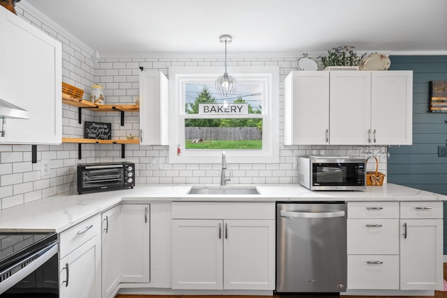 kitchen featuring appliances with stainless steel finishes, a sink, open shelves, backsplash, and white cabinetry