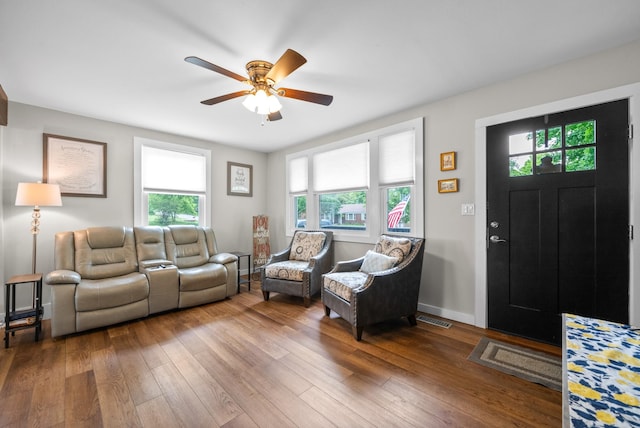 living area with healthy amount of natural light, ceiling fan, and hardwood / wood-style floors