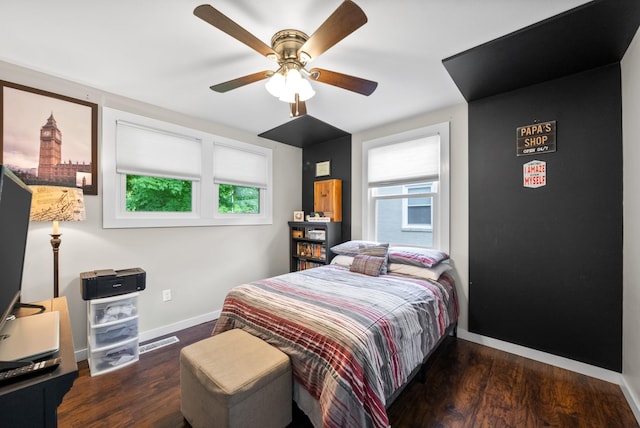 bedroom featuring multiple windows, wood finished floors, and baseboards