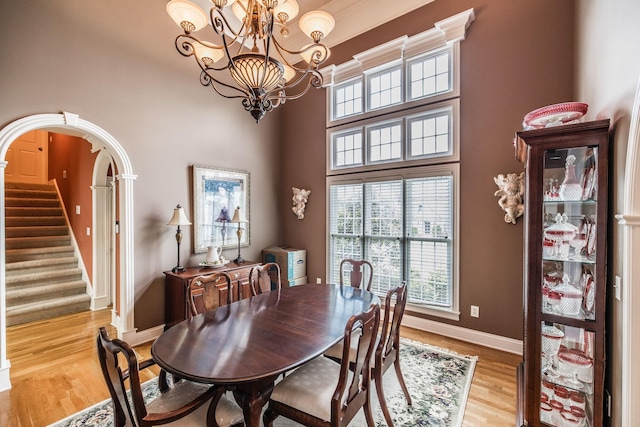 131 Grandview Cir, Gallatin, TN 37066 - dining space featuring a chandelier, baseboards, light wood-style floors, stairway, and a towering ceiling