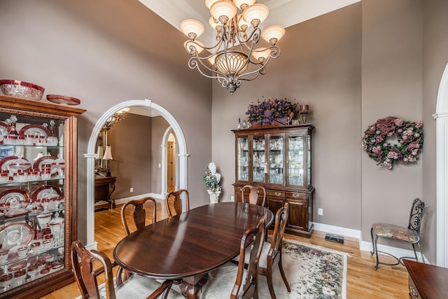 131 Grandview Cir, Gallatin, TN 37066 - dining space with a towering ceiling, light wood finished floors, a chandelier, baseboards, and arched walkways