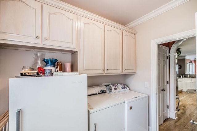 131 Grandview Cir, Gallatin, TN 37066 - laundry area with cabinet space, washing machine and dryer, ornamental molding, wood finished floors, and arched walkways