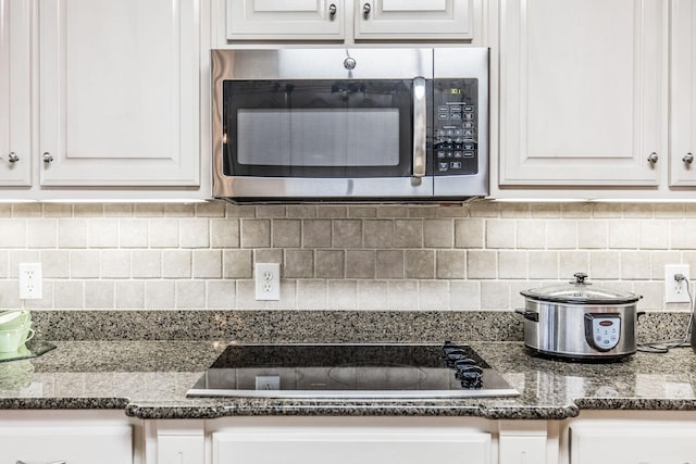 131 Grandview Cir, Gallatin, TN 37066 - kitchen with stainless steel microwave, black electric stovetop, white cabinets, and decorative backsplash