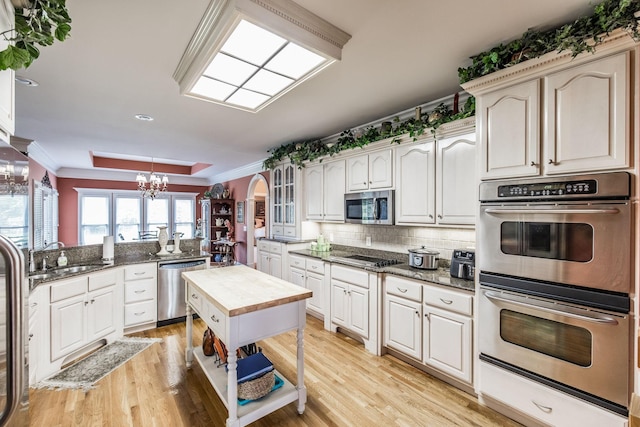131 Grandview Cir, Gallatin, TN 37066 - kitchen with appliances with stainless steel finishes, arched walkways, a chandelier, ornamental molding, and a sink